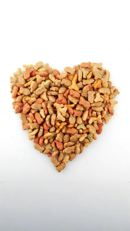 Herzform aus gemischtem Trockenfutter auf weißem Hintergrund.